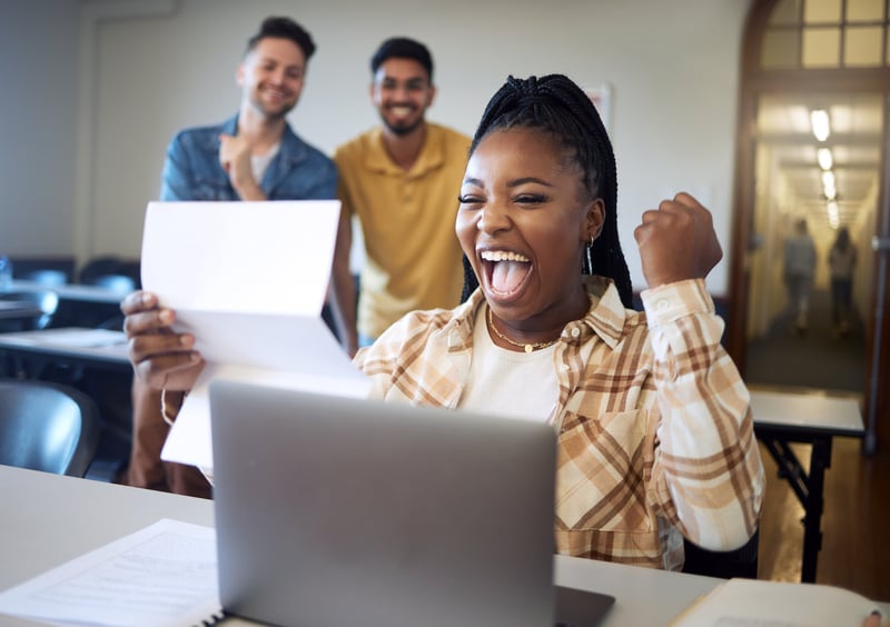 woman excitedly looking at paper in school setting